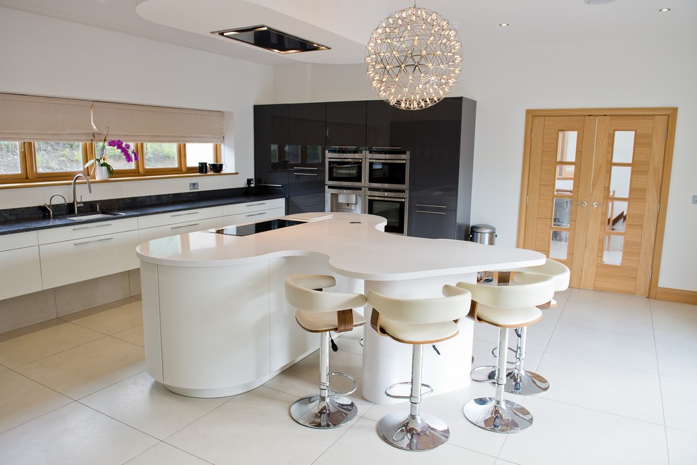 Immagine di una grande cucina design con lavello sottopiano, ante bianche, top in superficie solida, pavimento in travertino e ante lisce