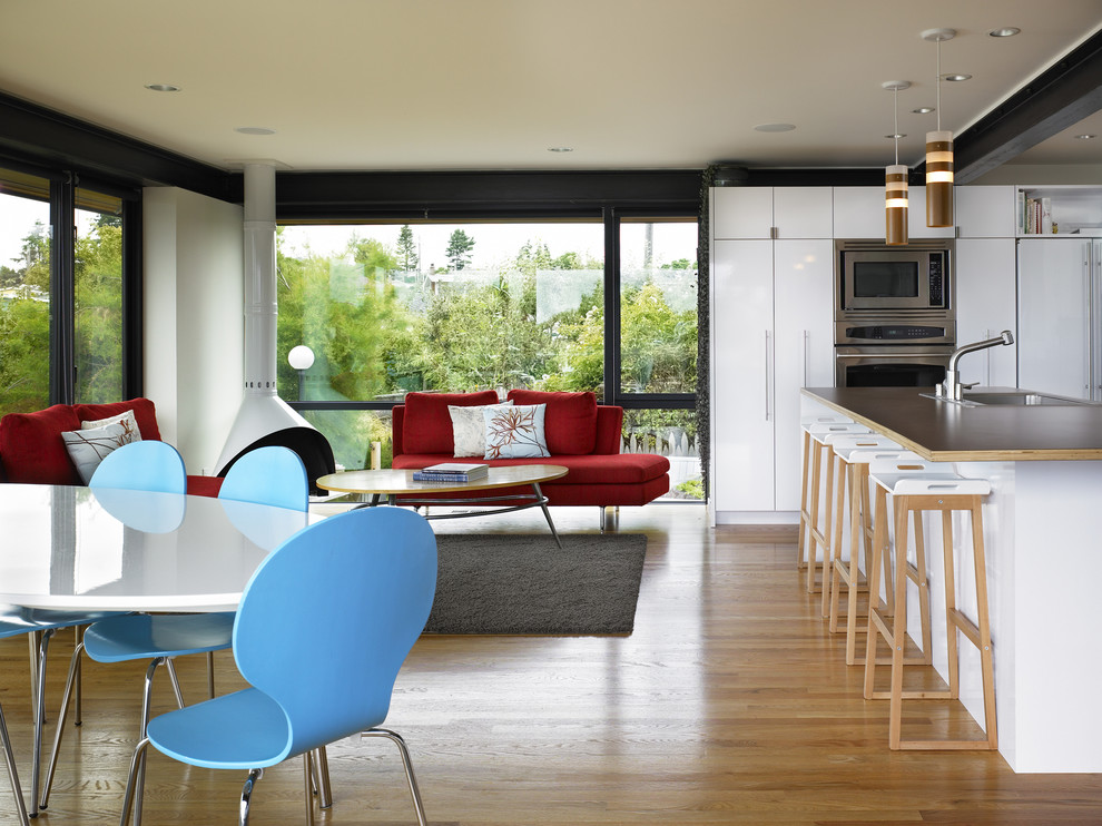 Offene Moderne Küche mit flächenbündigen Schrankfronten, weißen Schränken, Laminat-Arbeitsplatte und Küchengeräten aus Edelstahl in Seattle