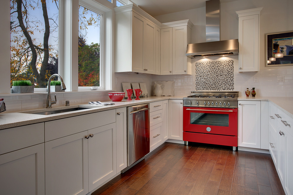 Example of a transitional open concept kitchen design in Seattle with recessed-panel cabinets, white cabinets, black backsplash, colored appliances and an undermount sink
