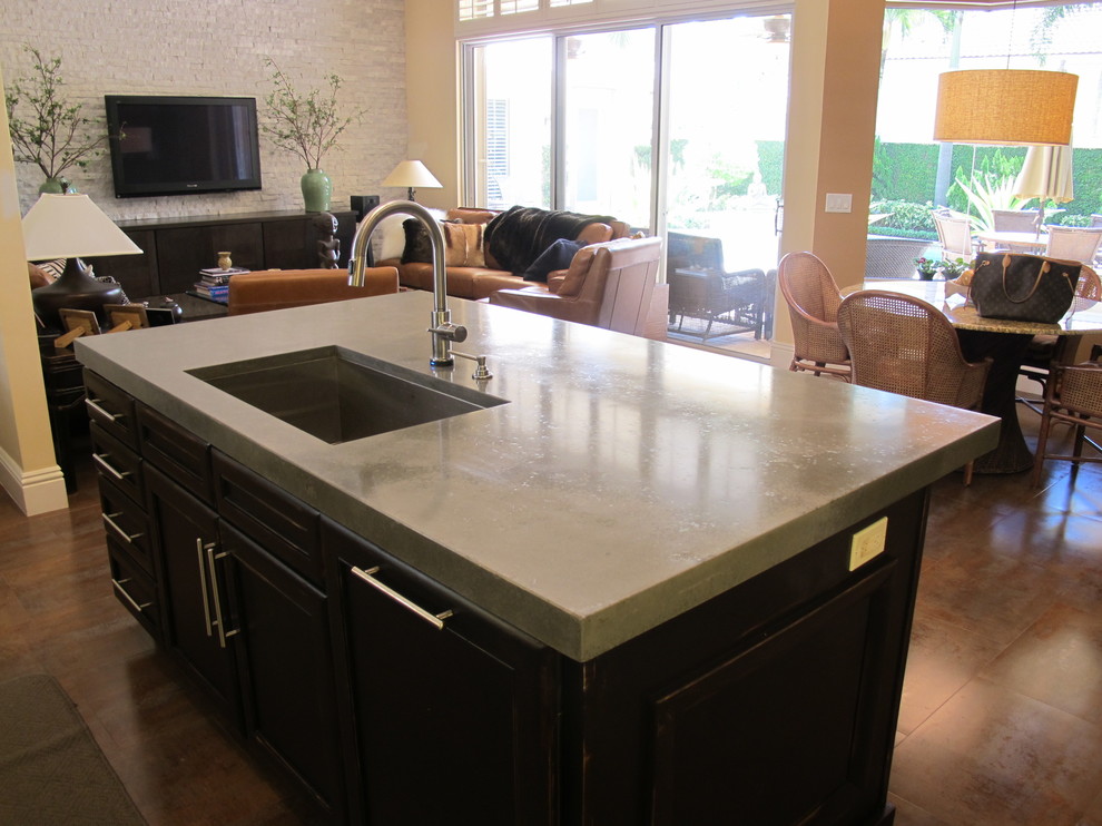 This is an example of a medium sized classic galley open plan kitchen in Miami with a submerged sink, flat-panel cabinets, dark wood cabinets, concrete worktops, stainless steel appliances, concrete flooring and an island.