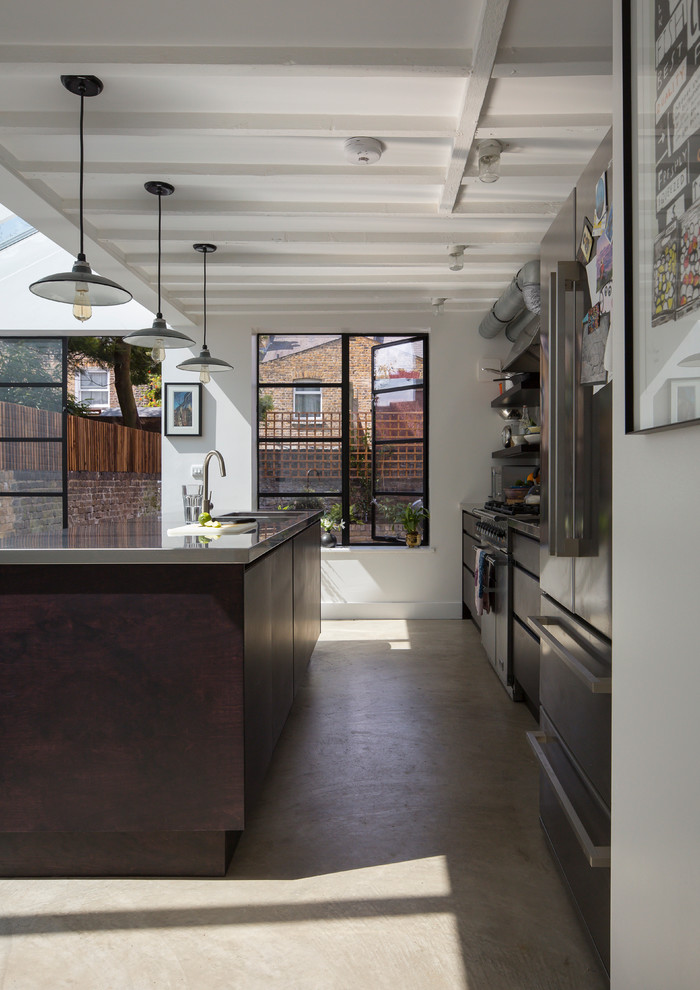 Exempel på ett modernt kök, med bänkskiva i rostfritt stål, rostfria vitvaror, en köksö och betonggolv