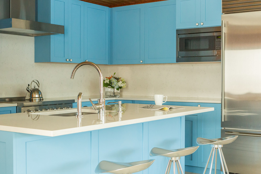 Inspiration for a traditional kitchen in Portland Maine with shaker cabinets, blue cabinets, engineered stone countertops, white splashback, stainless steel appliances and an island.