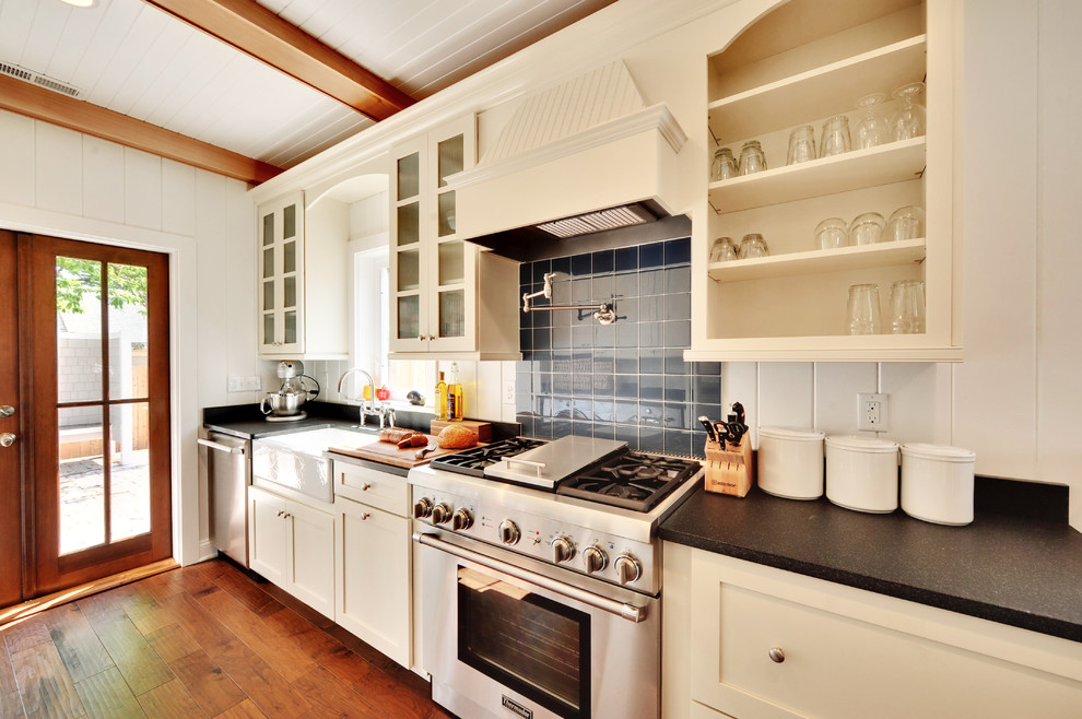 Modelo de cocina clásica con armarios abiertos, electrodomésticos de acero inoxidable, fregadero sobremueble y puertas de armario beige