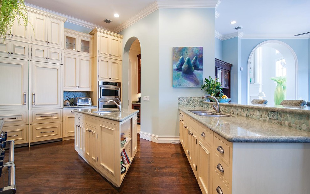 Foto på ett stort eklektiskt kök med öppen planlösning, med vita skåp, granitbänkskiva, blått stänkskydd, stänkskydd i mosaik, rostfria vitvaror, mellanmörkt trägolv, en köksö och en trippel diskho