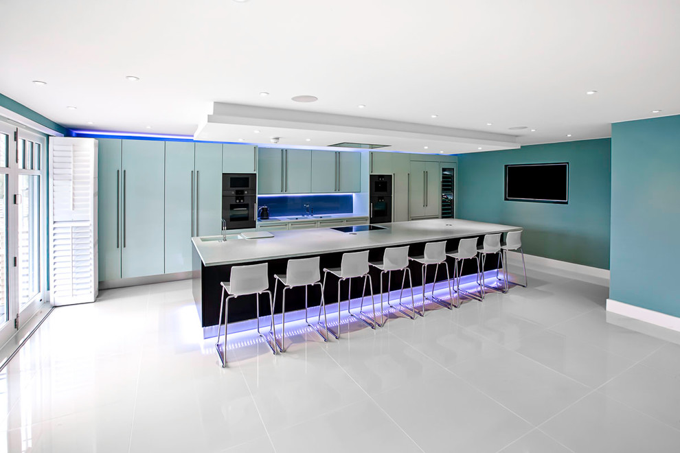 Esempio di una grande cucina minimalista con lavello integrato, ante lisce, ante blu, top in superficie solida, paraspruzzi blu, paraspruzzi con lastra di vetro, elettrodomestici colorati e pavimento in gres porcellanato
