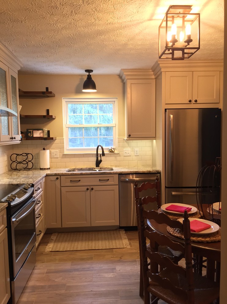 Rustikale Küche mit Doppelwaschbecken, profilierten Schrankfronten, beigen Schränken, Granit-Arbeitsplatte, Küchenrückwand in Weiß, Rückwand aus Terrakottafliesen, Küchengeräten aus Edelstahl und braunem Boden in Cincinnati