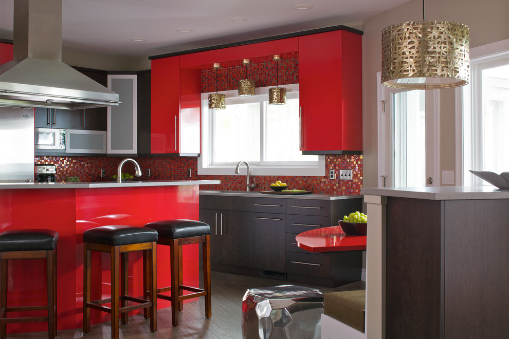 Bild på ett mellanstort funkis kök, med en undermonterad diskho, släta luckor, skåp i mörkt trä, bänkskiva i kvarts, rött stänkskydd, stänkskydd i glaskakel, rostfria vitvaror och en halv köksö