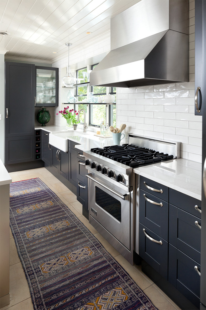 Inspiration for a classic kitchen in Minneapolis with a belfast sink, shaker cabinets, blue cabinets, white splashback, metro tiled splashback and stainless steel appliances.