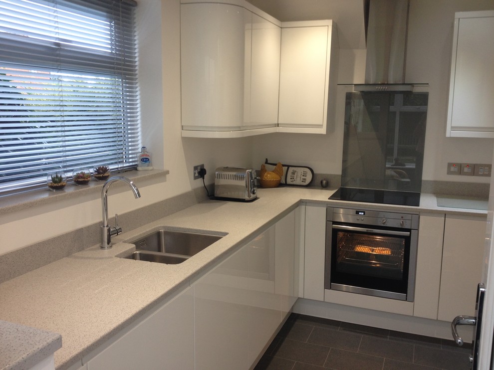 Photo of a medium sized l-shaped kitchen/diner in Other with flat-panel cabinets, white cabinets, quartz worktops and no island.