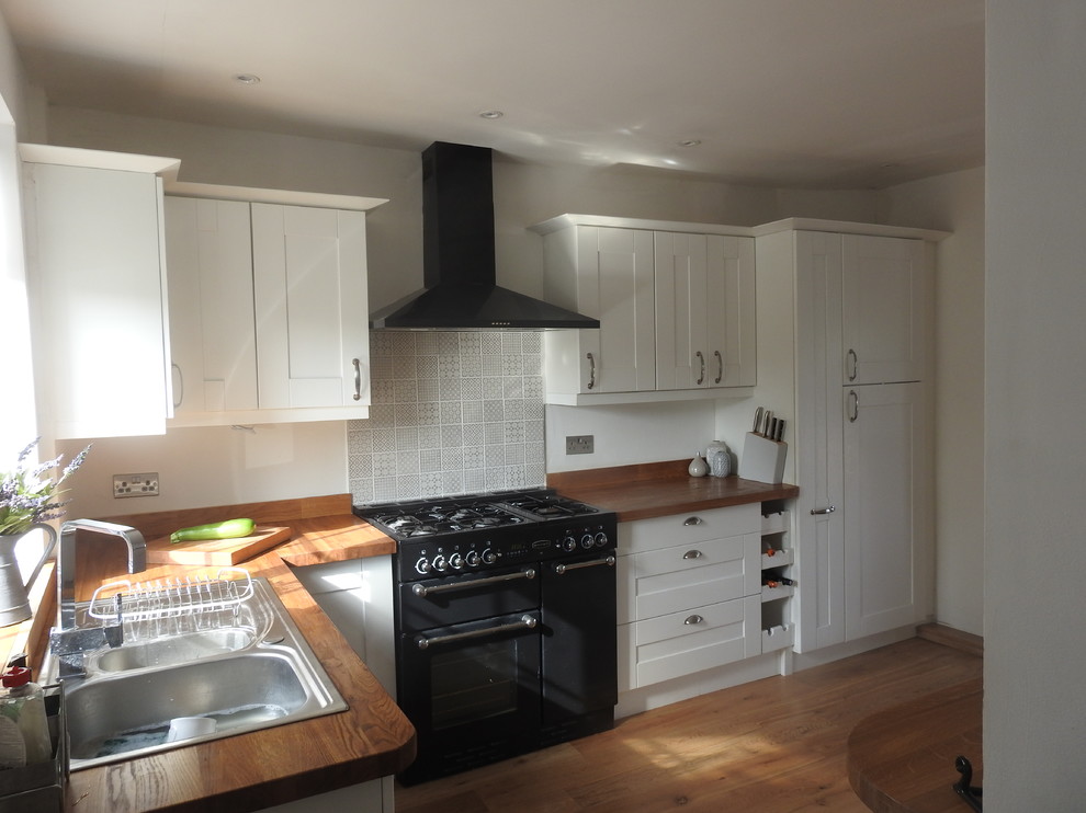 Foto di una cucina classica di medie dimensioni con ante in stile shaker, ante bianche, top in legno e nessuna isola