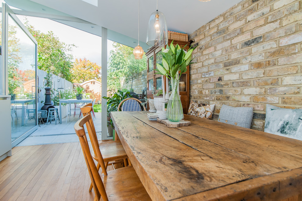 Cette image montre une salle à manger ouverte sur la cuisine traditionnelle de taille moyenne avec un sol en bois brun.