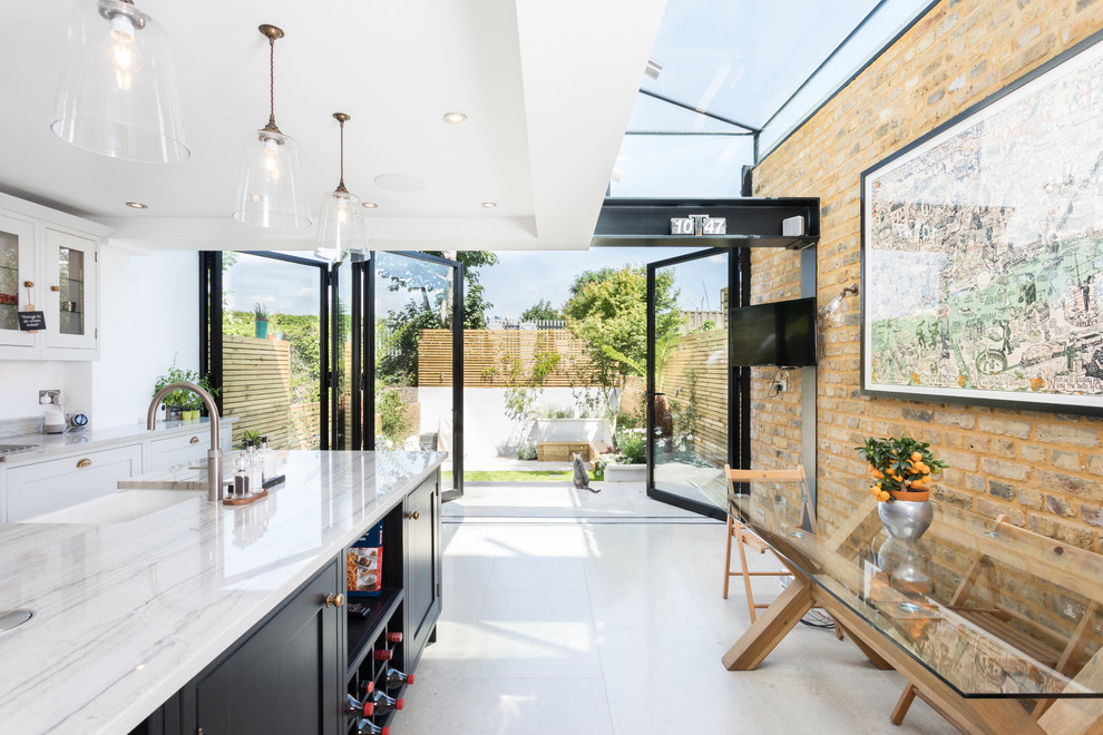 Mittelgroße Moderne Wohnküche mit Landhausspüle, Granit-Arbeitsplatte, Kücheninsel und weißem Boden in Sonstige