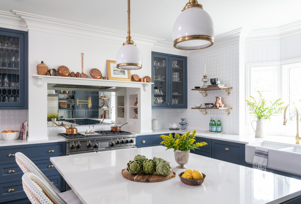Foto di una cucina con lavello stile country, ante blu, paraspruzzi bianco, elettrodomestici in acciaio inossidabile, parquet scuro e top bianco