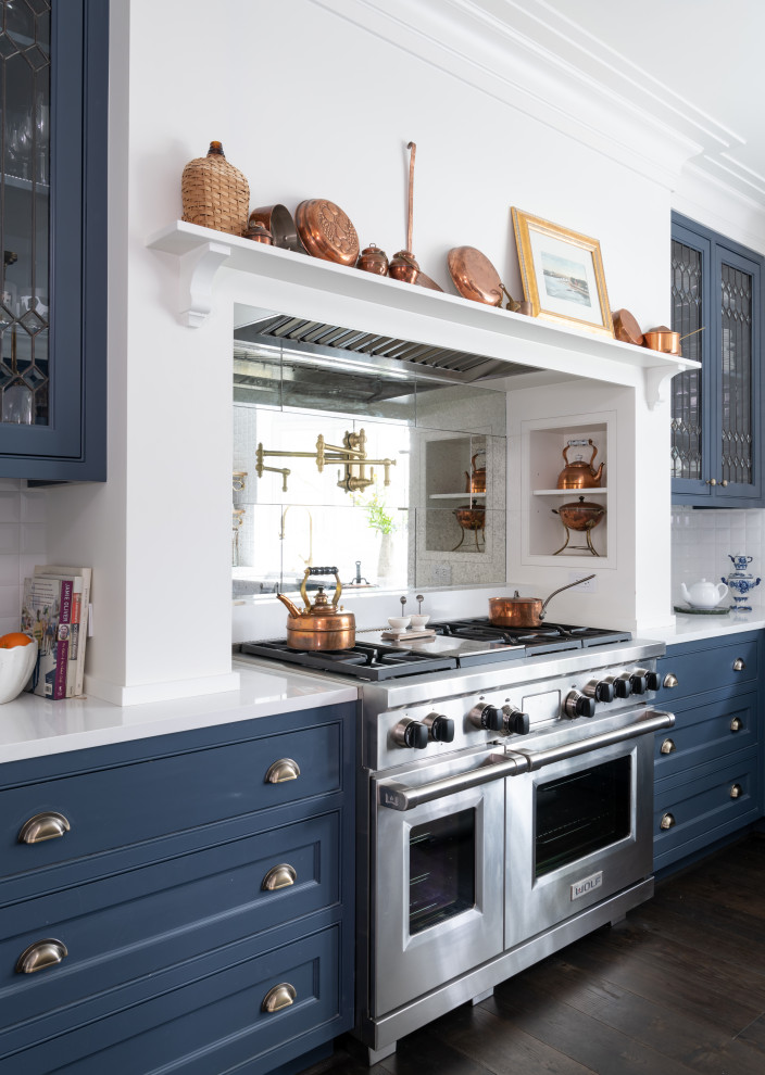 Esempio di una cucina con lavello stile country, ante blu, paraspruzzi bianco, elettrodomestici in acciaio inossidabile, parquet scuro e top bianco
