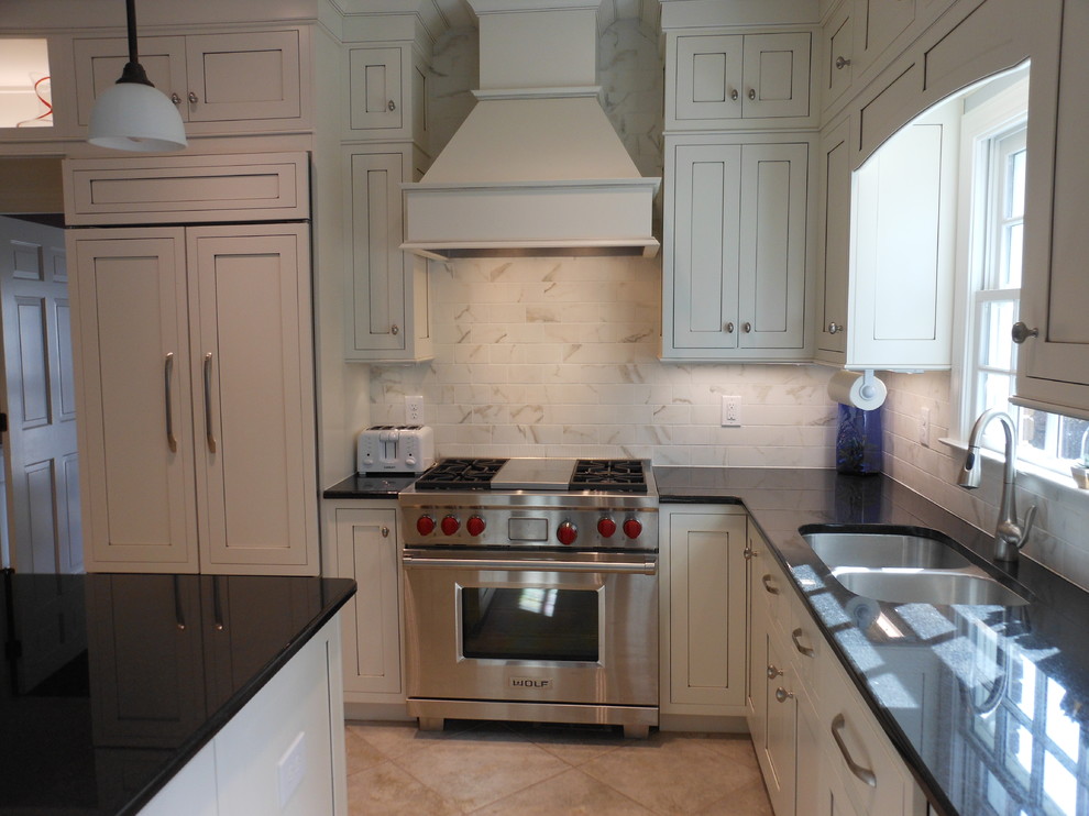 Foto di una cucina classica con lavello sottopiano, ante in stile shaker, ante bianche, top in granito, paraspruzzi bianco, paraspruzzi con piastrelle in ceramica e elettrodomestici in acciaio inossidabile
