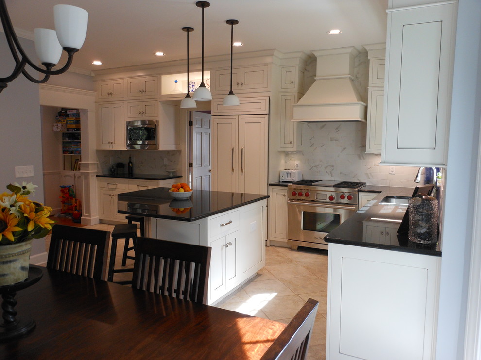 Inspiration for a timeless l-shaped eat-in kitchen remodel in Birmingham with an undermount sink, shaker cabinets, white cabinets, granite countertops, white backsplash, ceramic backsplash and stainless steel appliances