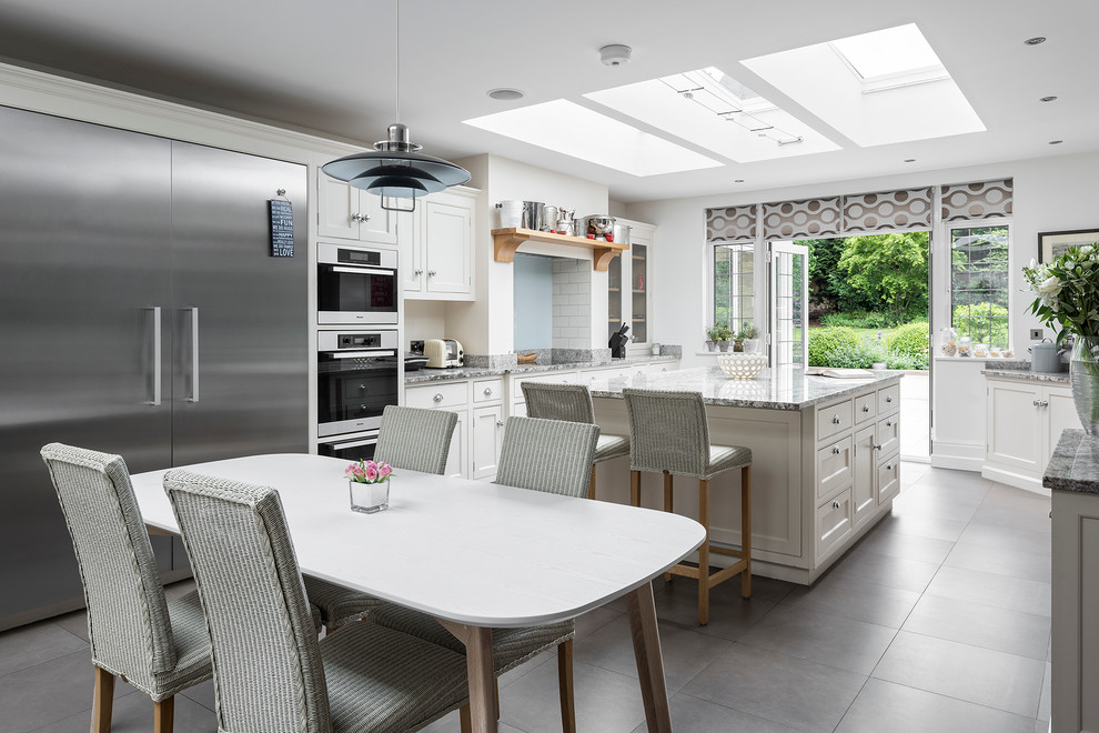 Inspiration for a medium sized classic l-shaped kitchen/diner in Hampshire with shaker cabinets, marble worktops, ceramic splashback, integrated appliances, slate flooring and an island.