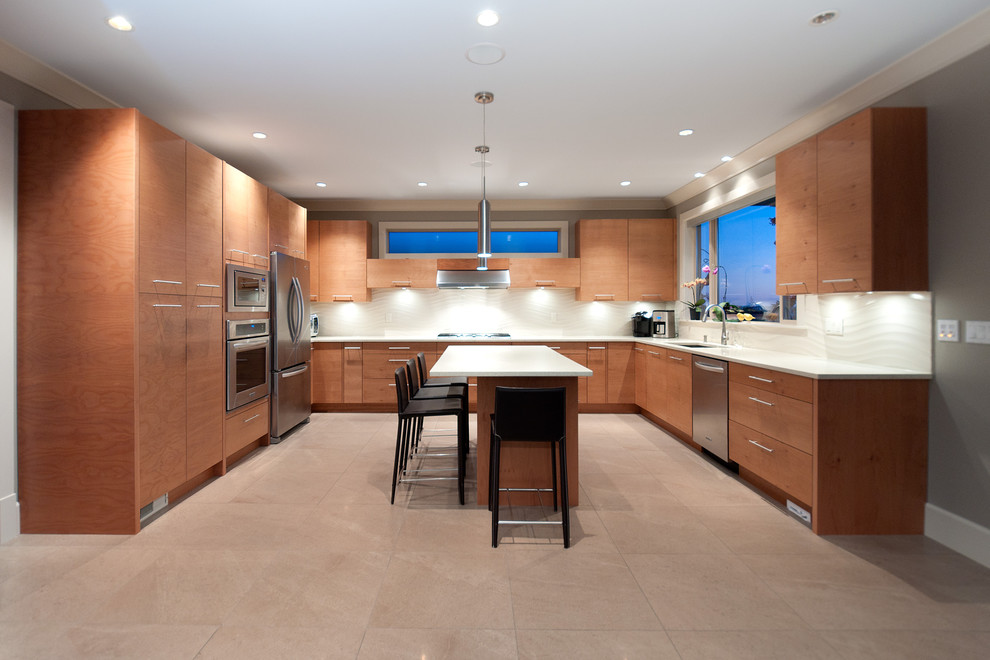 Cette photo montre une cuisine tendance en U et bois brun avec un évier encastré, un placard à porte plane, une crédence beige et un électroménager en acier inoxydable.