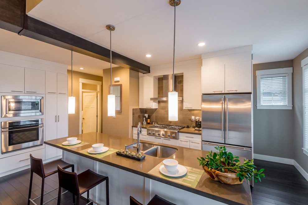 Example of a minimalist single-wall dark wood floor kitchen design in DC Metro with a double-bowl sink, flat-panel cabinets, white cabinets, quartzite countertops, gray backsplash, porcelain backsplash, stainless steel appliances and an island