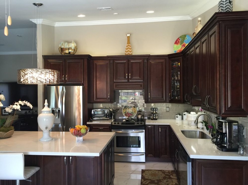 Example of a mid-sized classic u-shaped marble floor and white floor eat-in kitchen design in Miami with an undermount sink, raised-panel cabinets, dark wood cabinets, quartz countertops, gray backsplash, subway tile backsplash, stainless steel appliances, an island and white countertops