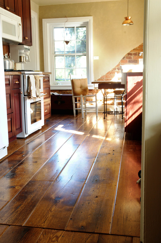 Mittelgroße Landhausstil Wohnküche mit braunem Holzboden und braunem Boden in Sonstige
