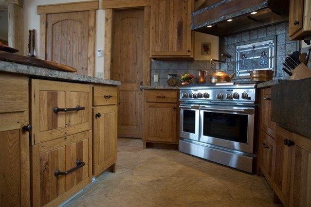 Inredning av ett rustikt stort kök, med en köksö, luckor med upphöjd panel, rostfria vitvaror, en nedsänkt diskho, bruna skåp, träbänkskiva, beige stänkskydd och stänkskydd i keramik
