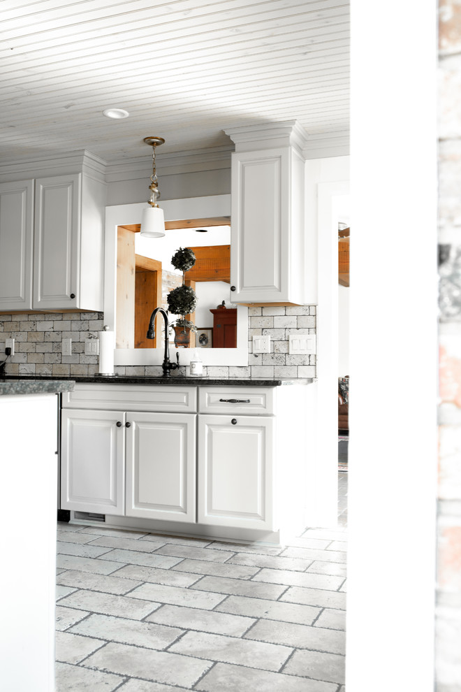 Idéer för mellanstora rustika svart kök, med en dubbel diskho, luckor med upphöjd panel, vita skåp, granitbänkskiva, beige stänkskydd, stänkskydd i tegel, rostfria vitvaror, klinkergolv i keramik och grått golv