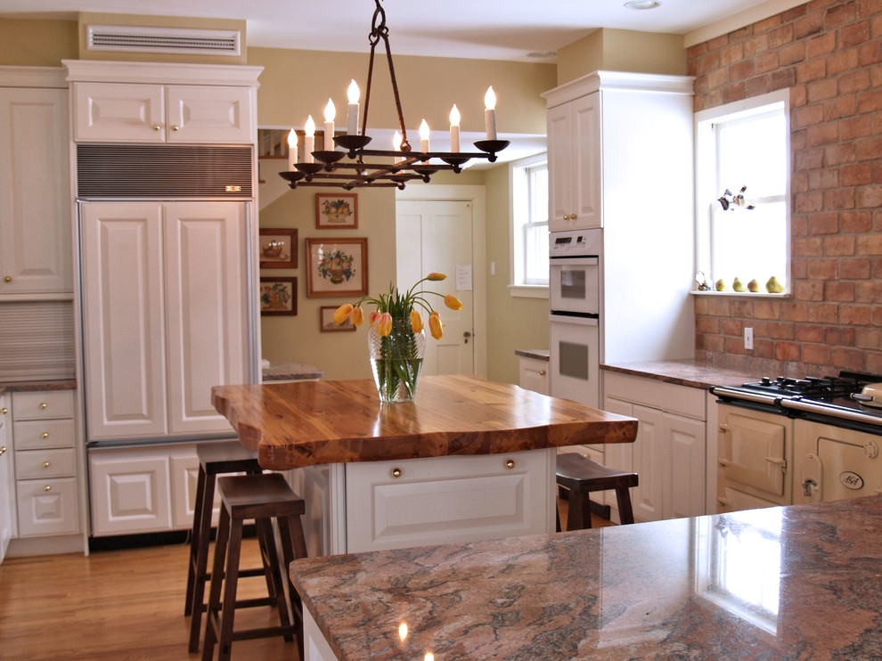 Inspiration for a large country l-shaped light wood floor eat-in kitchen remodel in Austin with raised-panel cabinets, white cabinets, wood countertops, beige backsplash, colored appliances and an island