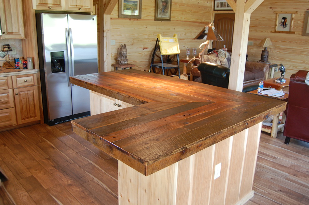 Immagine di una grande cucina stile rurale con ante in legno scuro, top in legno, paraspruzzi marrone, elettrodomestici in acciaio inossidabile e pavimento in legno massello medio