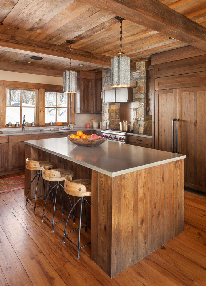 Bild på ett rustikt l-kök, med skåp i mellenmörkt trä, integrerade vitvaror, mellanmörkt trägolv och en köksö