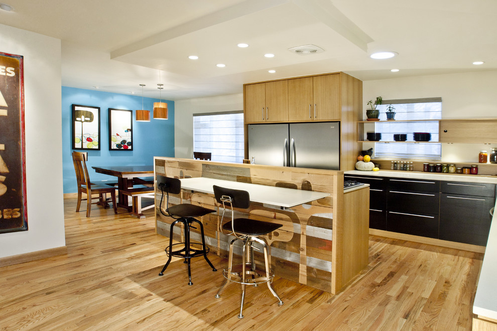 Moderne Küche in L-Form mit Küchengeräten aus Edelstahl, Quarzwerkstein-Arbeitsplatte, flächenbündigen Schrankfronten und schwarzen Schränken in Denver
