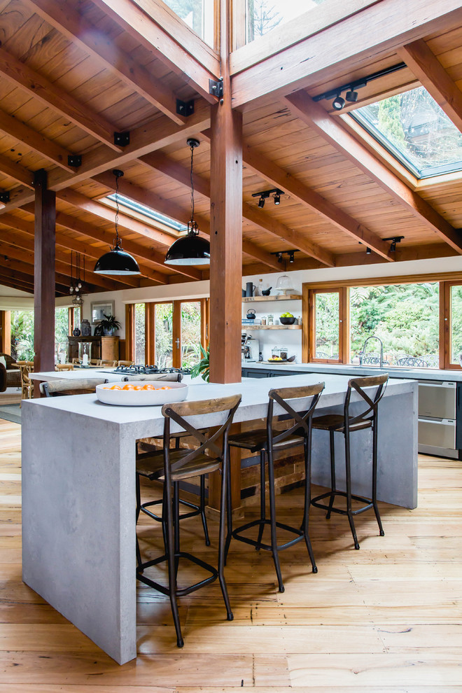 Example of a large mountain style galley medium tone wood floor and brown floor eat-in kitchen design in Melbourne with an undermount sink, shaker cabinets, black cabinets, quartz countertops, white backsplash, terra-cotta backsplash, an island, gray countertops and stainless steel appliances