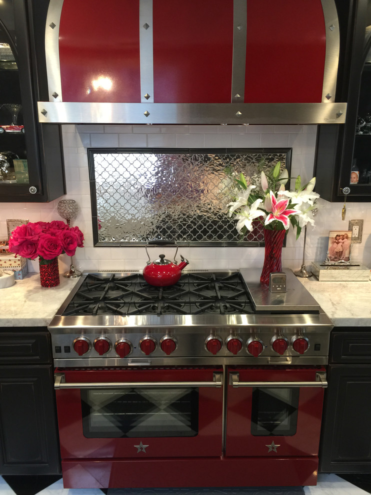 Immagine di una cucina ad U moderna con paraspruzzi a effetto metallico e elettrodomestici colorati