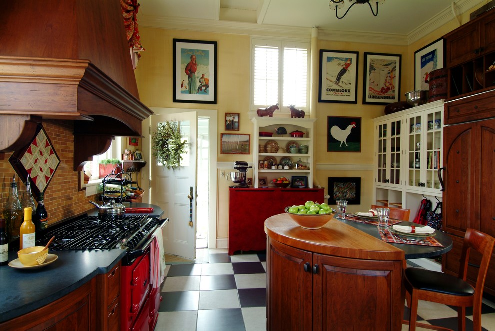Example of a mid-sized classic l-shaped ceramic tile and multicolored floor eat-in kitchen design in Boston with beaded inset cabinets, colored appliances, a farmhouse sink, medium tone wood cabinets, granite countertops, brown backsplash, ceramic backsplash and an island