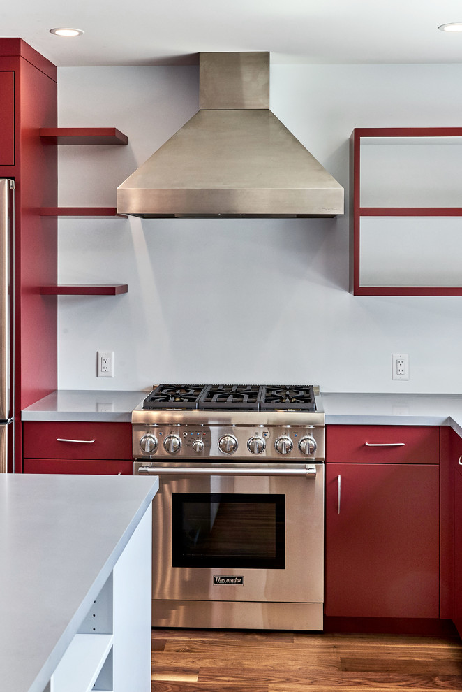 Bild på ett mellanstort funkis grå grått kök, med en undermonterad diskho, släta luckor, röda skåp, bänkskiva i koppar, rostfria vitvaror, mellanmörkt trägolv, en köksö och brunt golv