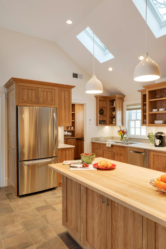 Klassische Küche mit hellbraunen Holzschränken, Küchengeräten aus Edelstahl und Keramikboden in Boston