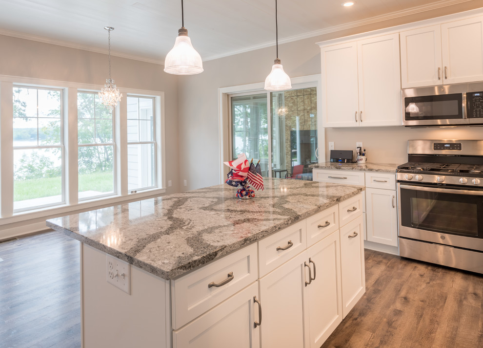 Medium sized classic l-shaped kitchen/diner in Minneapolis with a submerged sink, shaker cabinets, white cabinets, engineered stone countertops, grey splashback, vinyl flooring, an island and multicoloured worktops.