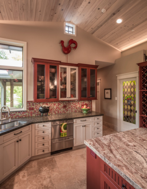 Foto de cocina tradicional de tamaño medio con puertas de armario rojas, salpicadero multicolor, electrodomésticos de acero inoxidable, suelo de baldosas de cerámica y una isla