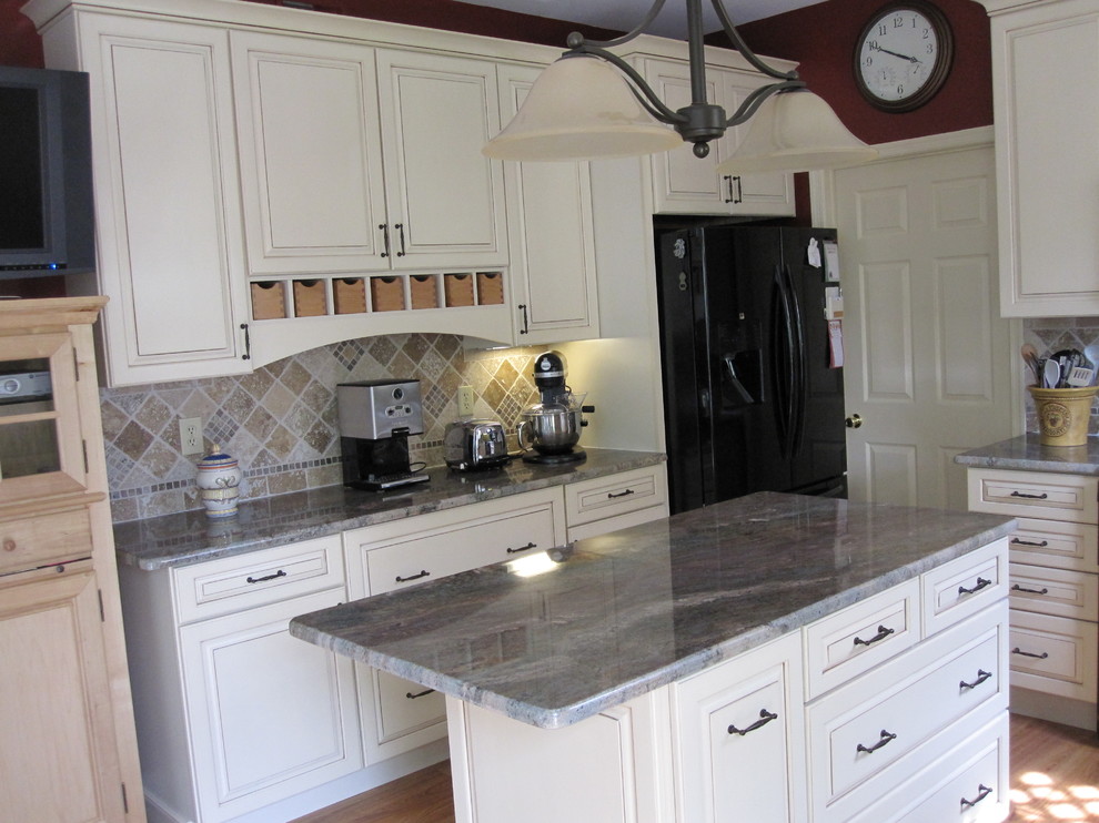 Example of a small classic u-shaped light wood floor eat-in kitchen design in Other with a double-bowl sink, flat-panel cabinets, white cabinets, granite countertops, brown backsplash, ceramic backsplash, colored appliances and an island