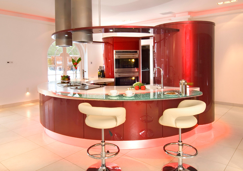 Inspiration for a large modern u-shaped open plan kitchen in London with an integrated sink, flat-panel cabinets, red cabinets, composite countertops, red splashback, glass sheet splashback, stainless steel appliances, porcelain flooring and a breakfast bar.