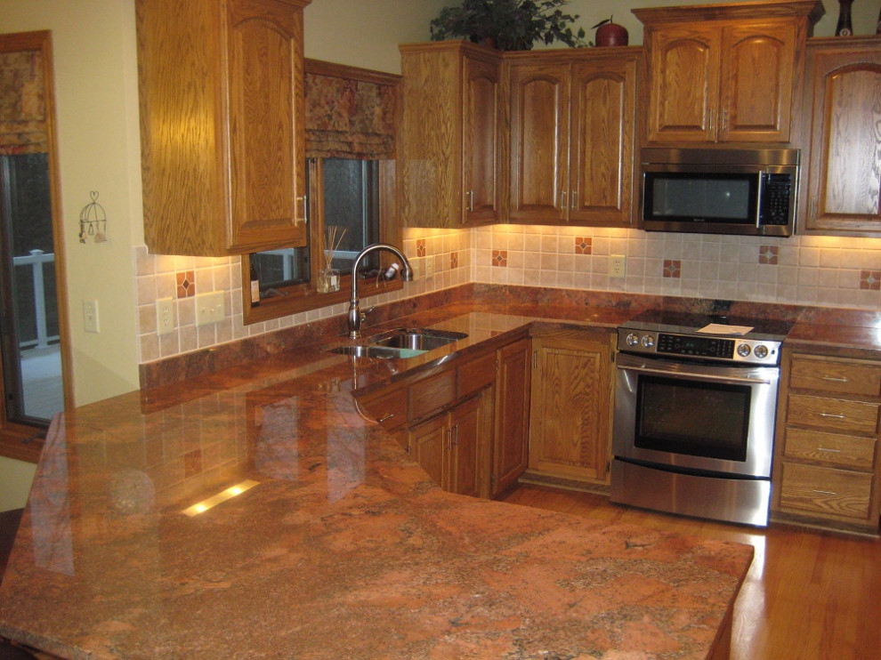 Cette image montre une cuisine rustique avec un plan de travail en granite et un plan de travail rouge.