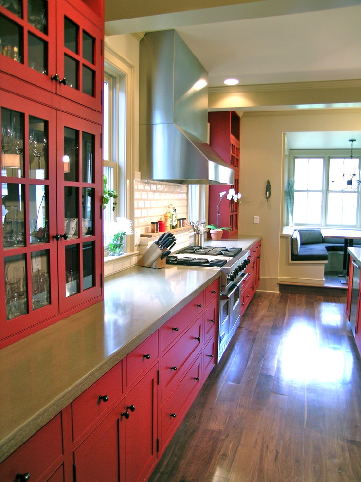 Bild på ett avskilt, stort vintage linjärt kök, med röda skåp, skåp i shakerstil, beige stänkskydd, stänkskydd i stenkakel, rostfria vitvaror, mörkt trägolv, en köksö, brunt golv och bänkskiva i betong