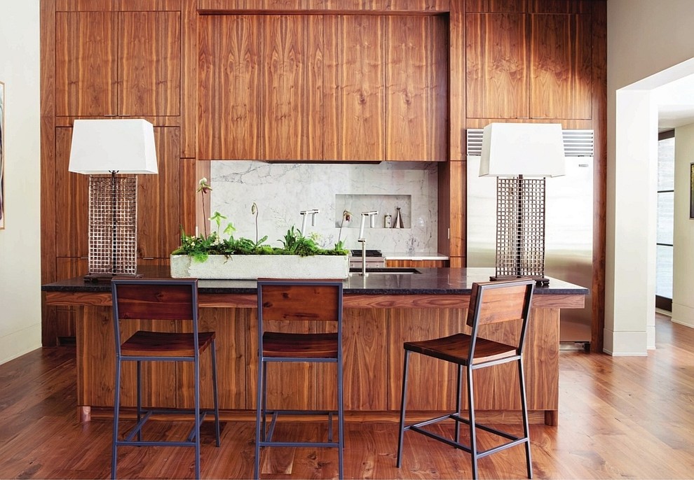 アトランタにあるモダンスタイルのおしゃれなII型キッチン (中間色木目調キャビネット、フラットパネル扉のキャビネット、白いキッチンパネル、石スラブのキッチンパネル、シルバーの調理設備) の写真