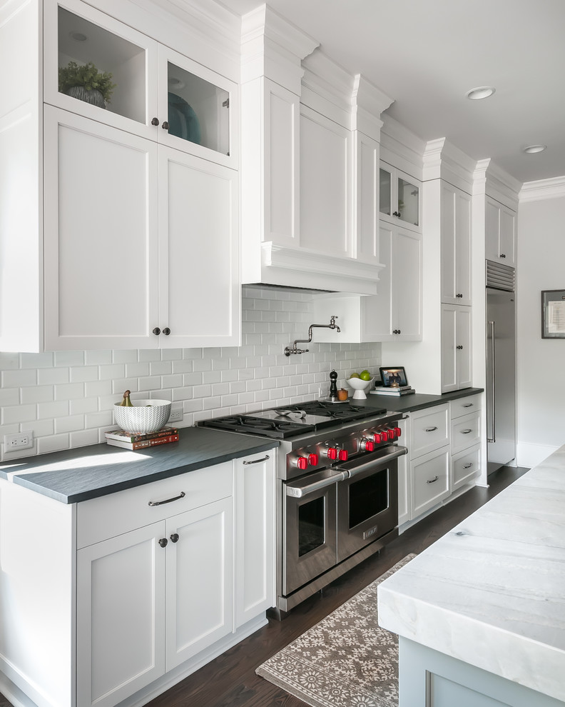 Eat-in kitchen - traditional galley dark wood floor and brown floor eat-in kitchen idea in Atlanta with a single-bowl sink, shaker cabinets, granite countertops, white backsplash, marble backsplash, stainless steel appliances, an island and black countertops
