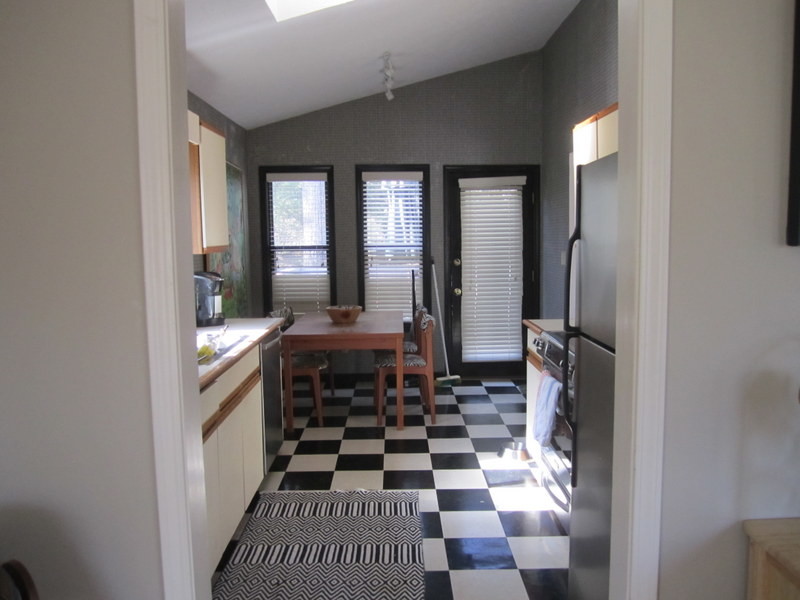Exempel på ett litet modernt kök, med släta luckor, vita skåp, träbänkskiva, rostfria vitvaror, vinylgolv och flerfärgat golv