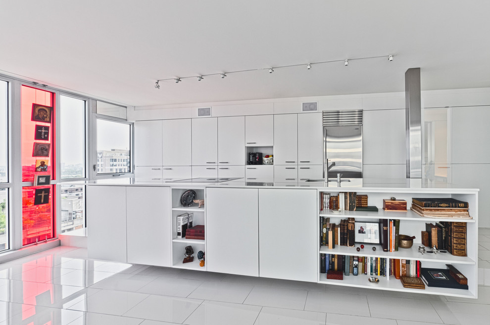 Modelo de cocina minimalista con armarios con paneles lisos, puertas de armario blancas y electrodomésticos de acero inoxidable