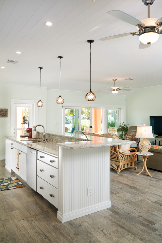 Inspiration for a mid-sized craftsman galley gray floor eat-in kitchen remodel in Tampa with an undermount sink, shaker cabinets, white cabinets, quartz countertops, gray backsplash, glass sheet backsplash, stainless steel appliances and an island