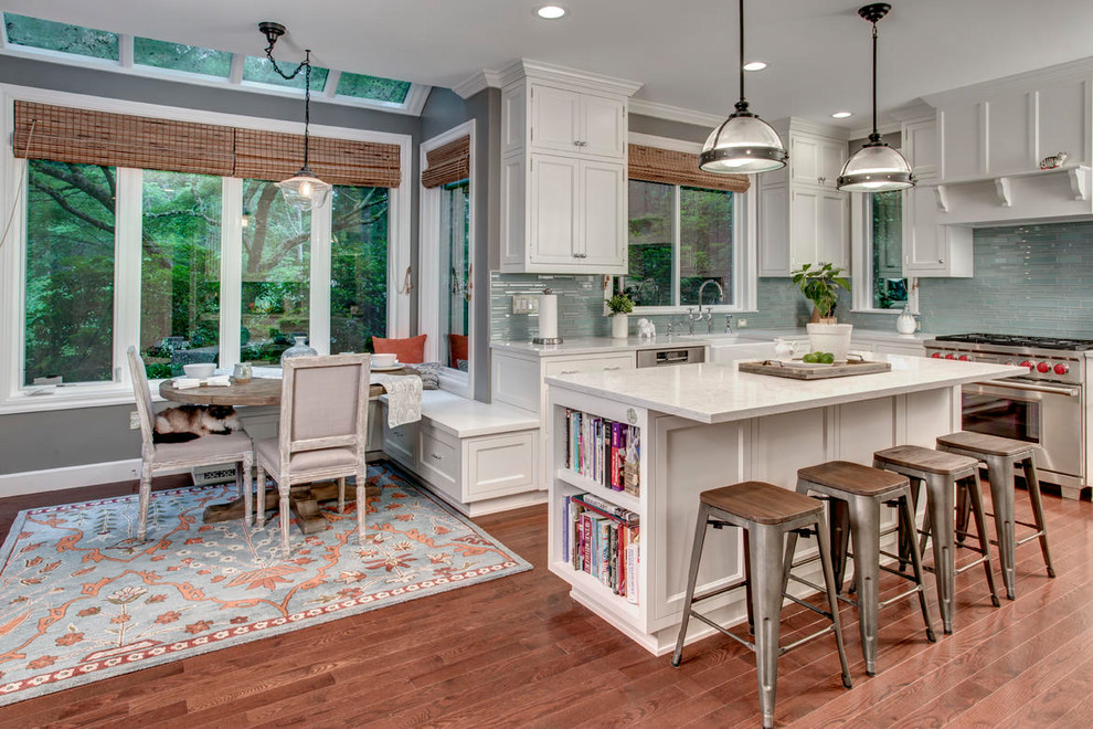 Inspiration for a large transitional l-shaped dark wood floor and brown floor eat-in kitchen remodel in Seattle with a farmhouse sink, white cabinets, blue backsplash, glass tile backsplash, stainless steel appliances, an island, white countertops, beaded inset cabinets and quartz countertops