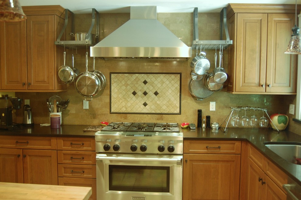 Bild på ett mellanstort vintage kök, med en enkel diskho, luckor med upphöjd panel, skåp i mellenmörkt trä, bänkskiva i täljsten, beige stänkskydd, stänkskydd i stenkakel, rostfria vitvaror, kalkstensgolv och en köksö