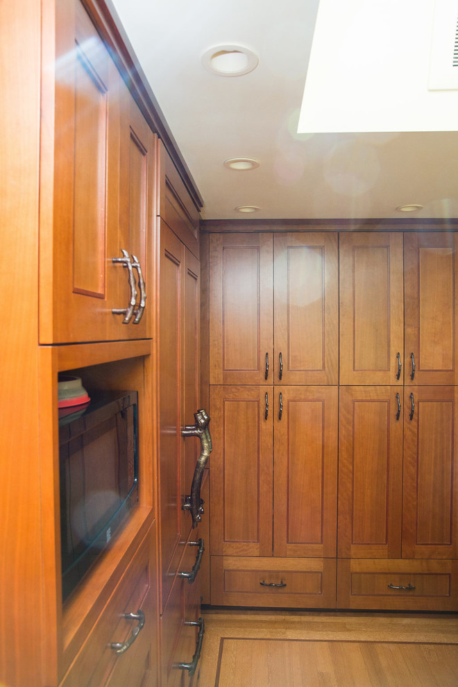 Exempel på ett mellanstort klassiskt kök, med luckor med infälld panel, skåp i mellenmörkt trä, granitbänkskiva, brunt stänkskydd, stänkskydd i glaskakel, rostfria vitvaror och en köksö